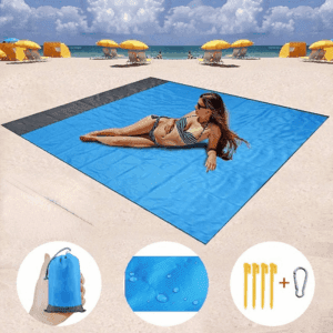 a woman lying on a blue blanket on a beach